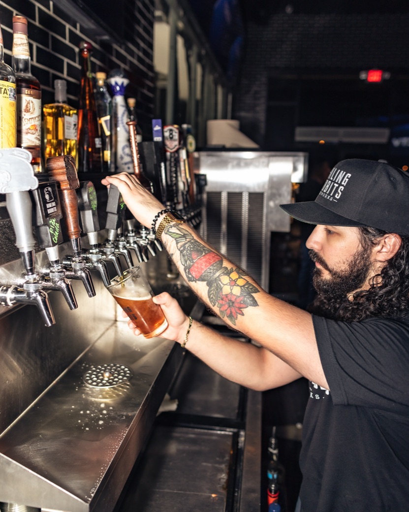Howling Rabbits bartender pouring a beer